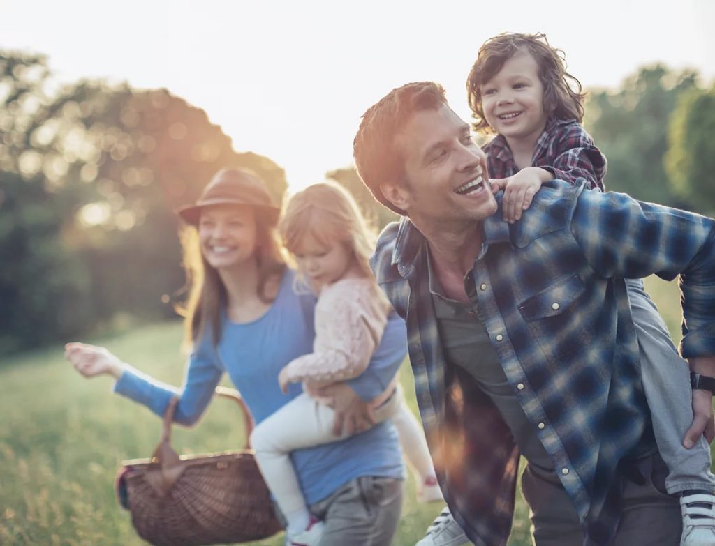 Happy family outdoors after their preventative dentistry appointments protected their smiles.