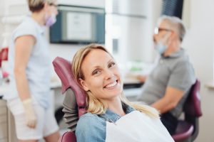 woman in dental chair smiling before dental exam