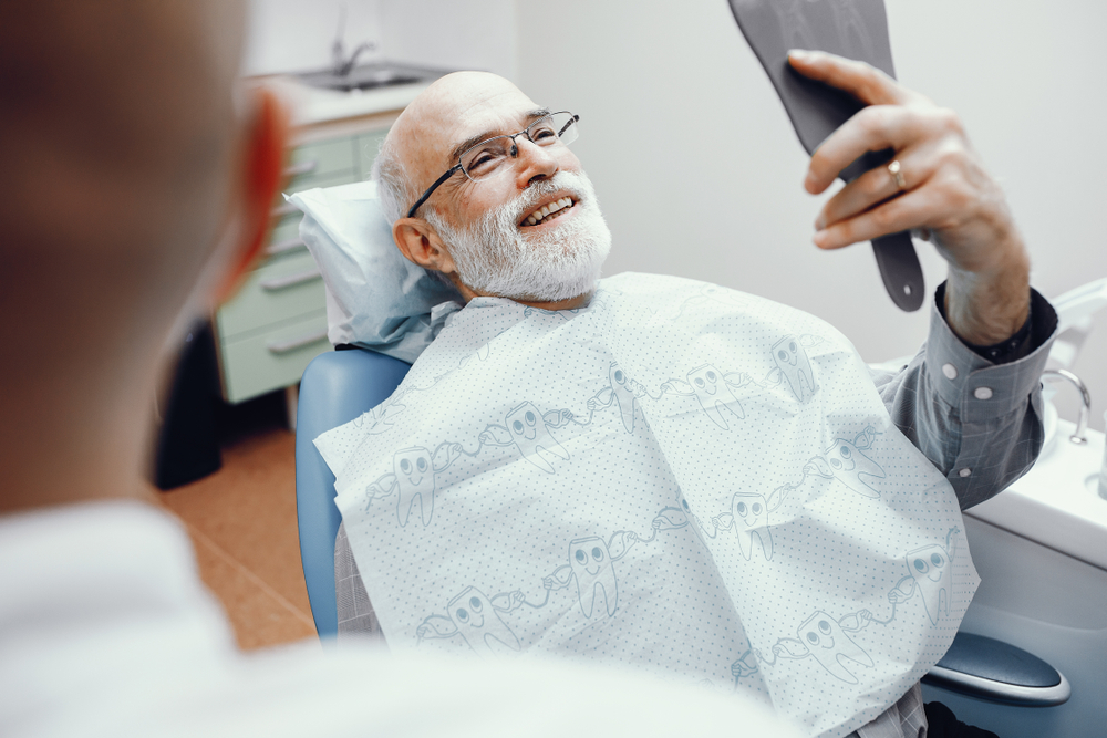 A man smiles at his dental appointment after receiving dental x-rays and imaging, enjoying preventative dentistry