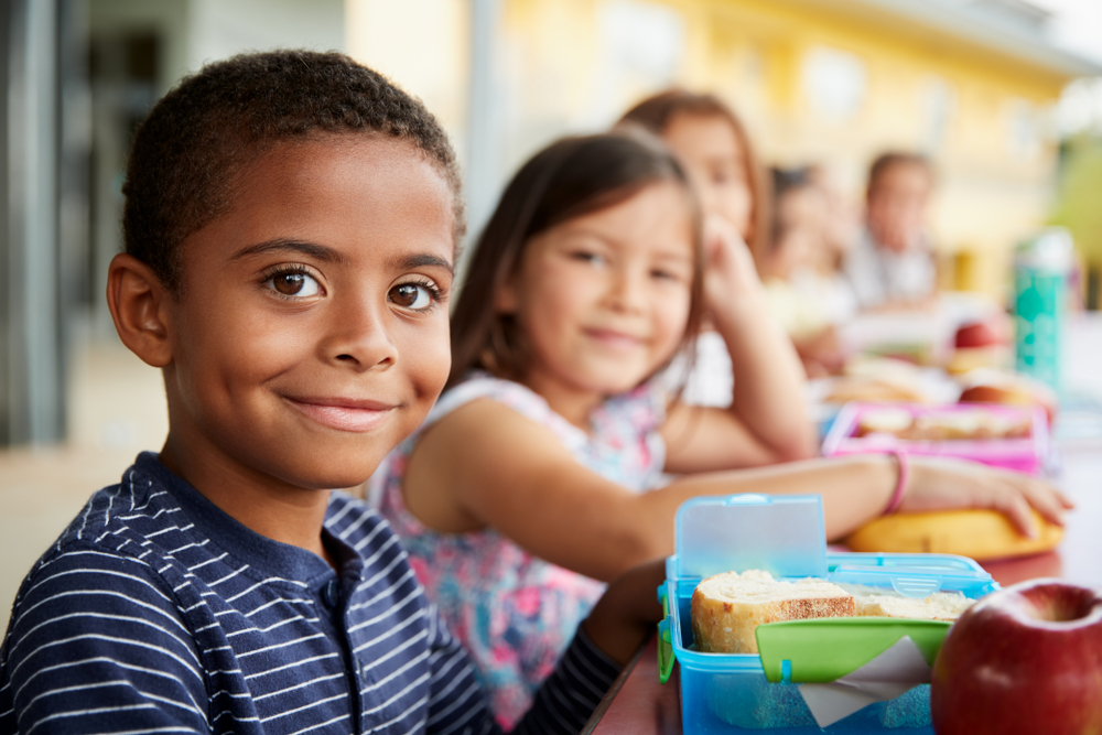 A child smiles at lunch knowing his teeth are protected using dental sealants