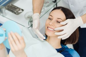 a woman is thrilled with the results of her dental crown procedure