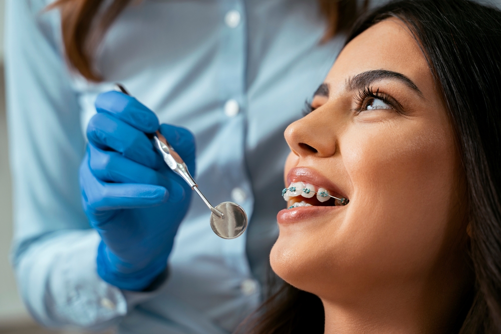 a girl has braces checked by her orthodontist